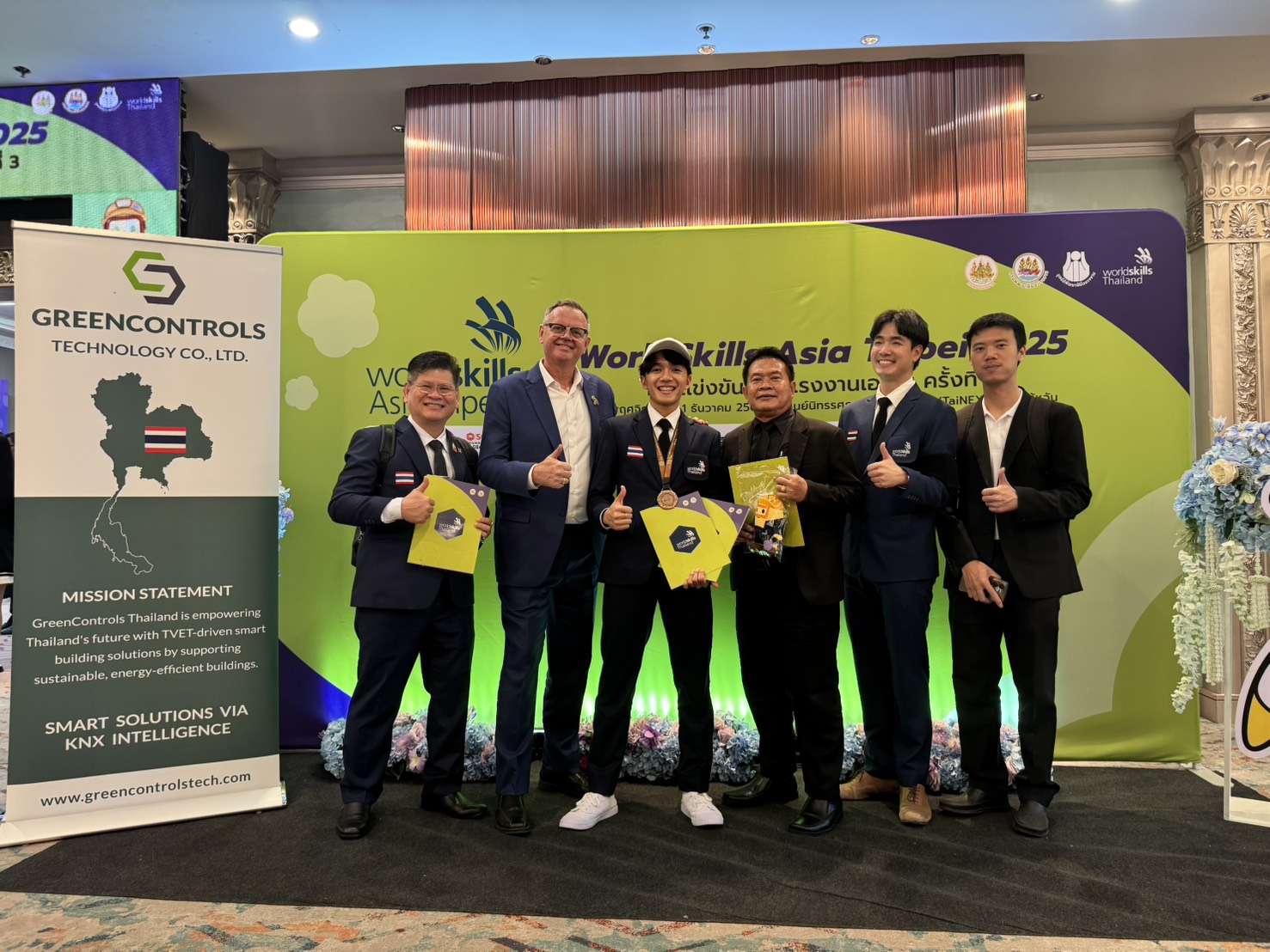 GreenControls Thailand team with the Thai competitor and supporters at WorldSkills Asia Taipei 2025, beside the GreenControls Technology banner