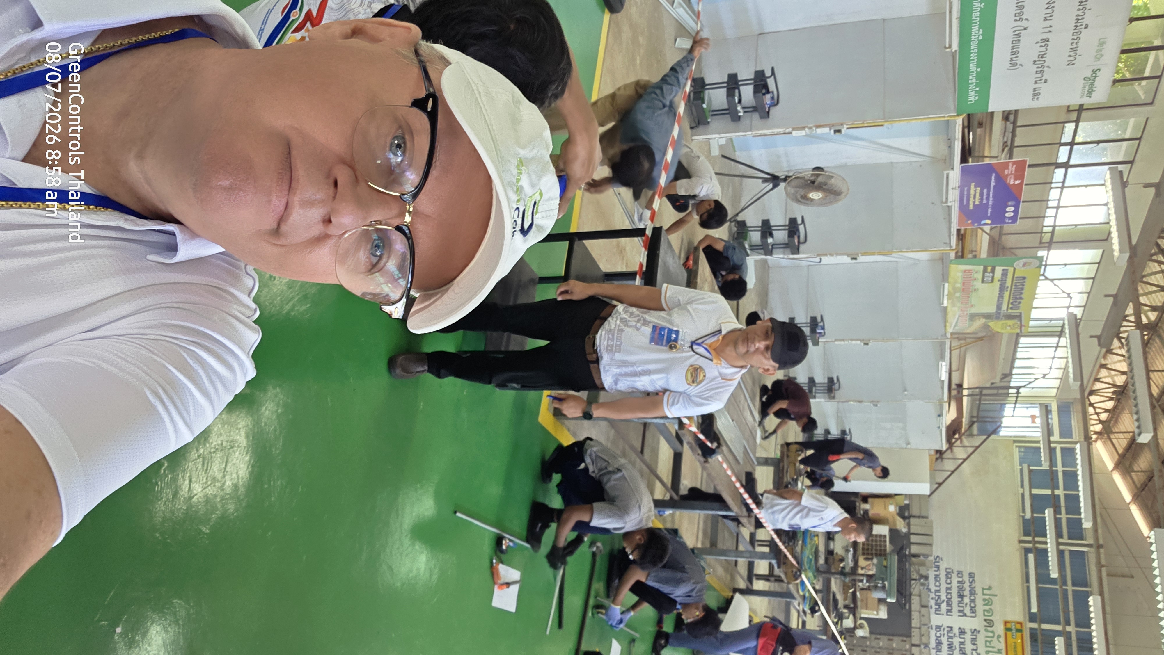 Practical electrical installation skills competition in progress at a technical training centre in Thailand, observed by a GreenControls Thailand representative
